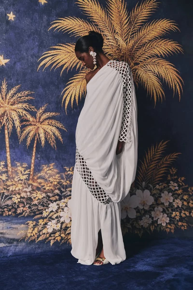 Draped ivory gown in front of a painted palm-tree backdrop